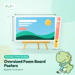 Large printed foam board poster standing on an easel beside a long narrow board